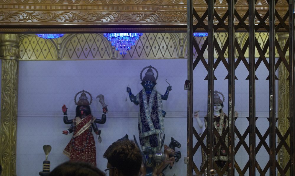 Santuario tras la reja bajo lámparas azules en Puran Dhaka
